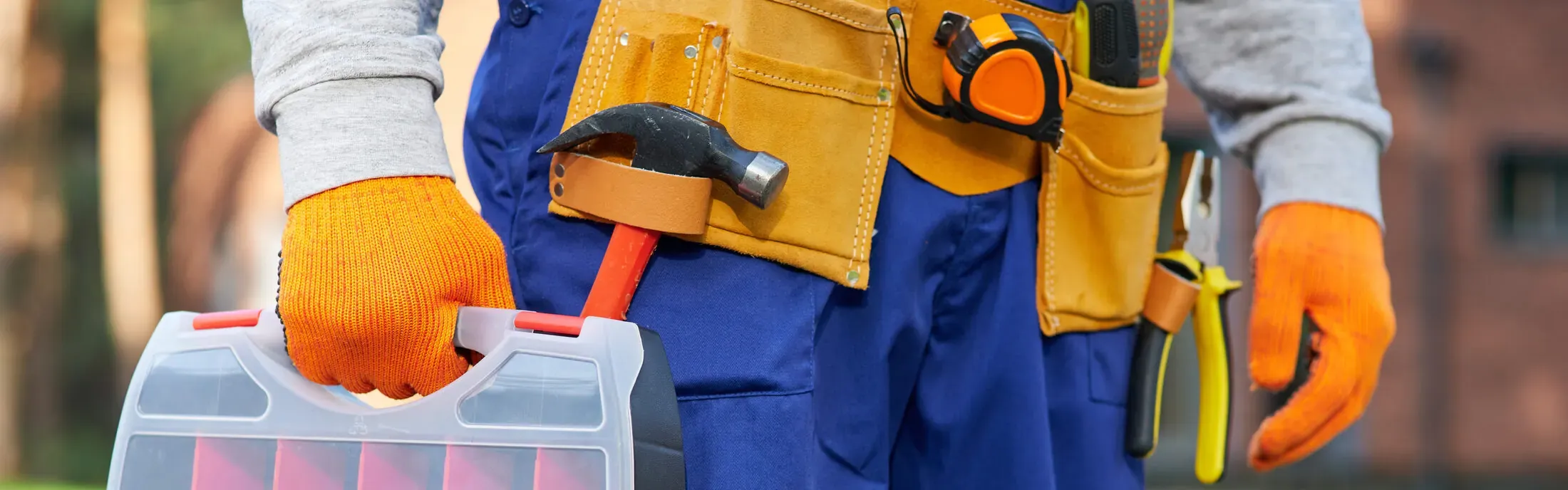Close-up of a plumber's tool belt with wrenches and fittings